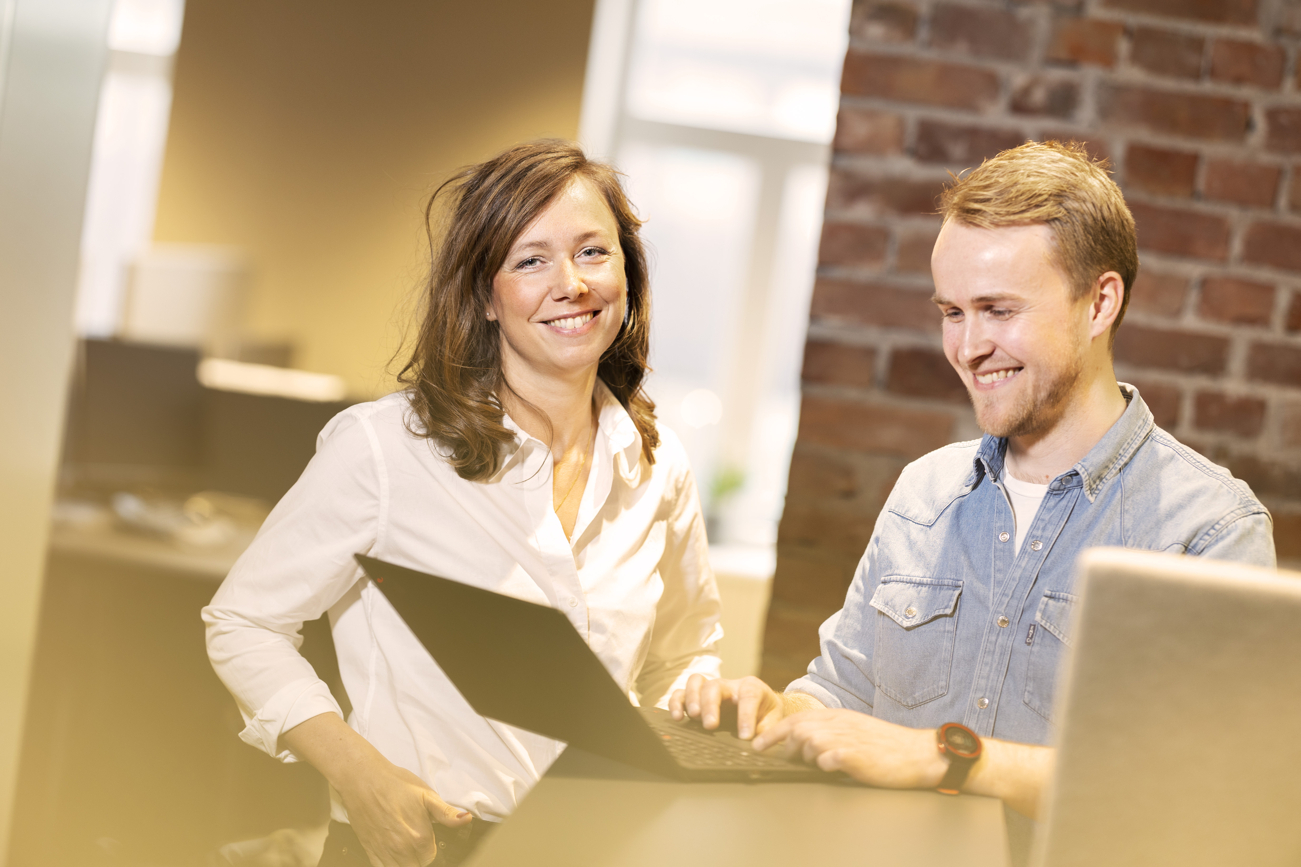 En dame og en mann sitter sammen foran en PC